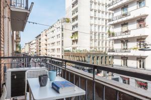 un tavolo con libri su un balcone con edifici di Flora Flexyrent apartment AC a Milano