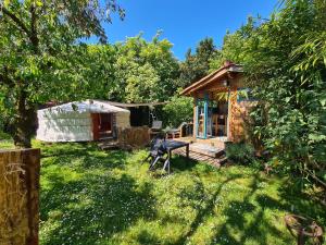 a yard with a house and a statue in the grass at La Yourte climatisée du Jardin Caché in Marmande
