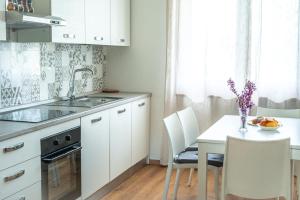 a kitchen with white cabinets and a table with chairs at Villa Rosa in Castiglione del Lago +15 photos