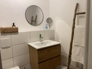 a bathroom with a sink and a mirror on the wall at Les Pommiers d'Amfreville, Chambres d'hôtes in Picauville