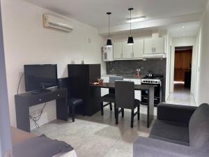 a kitchen and living room with a table and chairs at Apart Hotel Cañuelas in Cañuelas