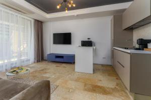 a living room with a couch and a tv on the wall at Astria Amalfi - Complex Novum in Olimp