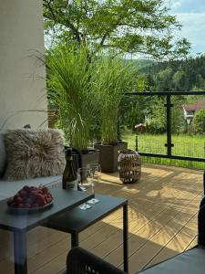 a table with a plate of fruit on a patio at Apartament Uzdrowiskowa I Prestige in Szczyrk