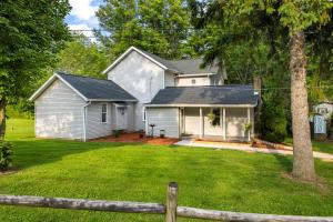 een wit huis met een hek in een tuin bij Entire House within Campground in Mifflinburg