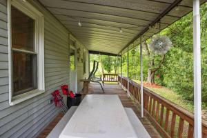 een veranda met een bank aan de zijkant van een huis bij Entire House within Campground in Mifflinburg