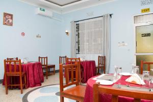 a dining room with tables and chairs with red table cloth at Kigongoni Gazella Hotel in Mto wa Mbu