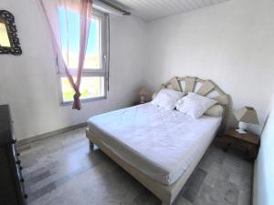 sypialnia z łóżkiem z białą pościelą i oknem w obiekcie 5013 Agde Marine G65 w Cap d'Agde +2 zdjęcia