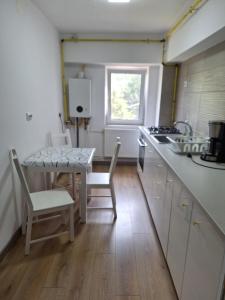 a kitchen with a table and a table and chairs at Mangalia Port in Mangalia