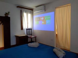 a bedroom with a blue bed and a projection screen at Mirabilia 2 in Chioggia