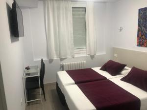 a bedroom with a bed and a television and a window at Barakaldo Rooms in Barakaldo +6 photos