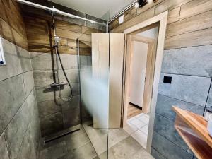 a bathroom with a shower with a glass door at La Perle de l'Eau - au bord du lac in Gérardmer +8 photos