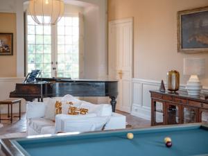 un soggiorno con un tavolo da biliardo e un pianoforte di Chateau Beaudesert - Piscine - Tennis - Parc de 50Ha a Corbarieu