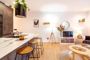 een keuken en een woonkamer met een aanrecht en krukken bij Penthouse by Unik Vacation in Tarragona