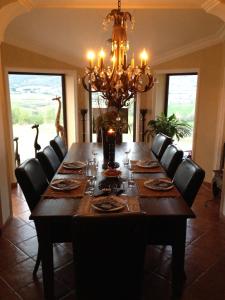 ヴィルヌーヴ・ド・ベルグにあるChambres d'hotes Belle Etoile Ardècheのダイニングルーム(椅子、シャンデリア付)