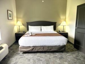 a bedroom with a large bed with two night stands at Midland Inn & Suites in Midland
