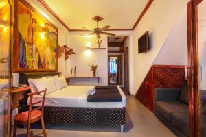 a bedroom with a bed and a chair and a couch at Villa Surf Beach in Galle