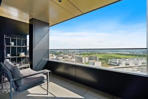 a chair in a room with a large window at Luxurious City Retreat Balcony & Pool Access in Luxembourg