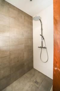 a shower with a shower head in a bathroom at Villa Contemporaine Piscine à Débordement Montpellier in Montpellier