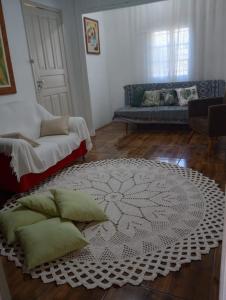 a living room with a couch and a rug at Simples e confortável in Londrina