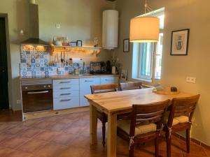 a kitchen with a wooden table and a dining room at Manor Meeder in Castanheira de Pêra