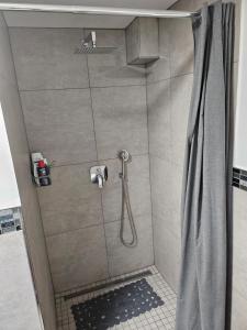 a shower with a shower curtain in a bathroom at Messelodge Deiker Höfe in Düsseldorf +5 photos