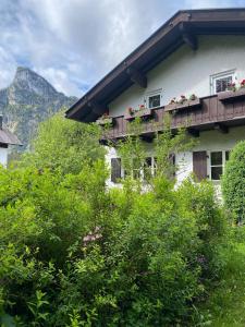 a building with a balcony with flowers on it at Ferienhaus Valentin in Oberammergau in Oberammergau