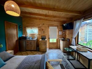 a room with a bed and a kitchen in a cabin at Siempre Verde in Puerto Tranquilo