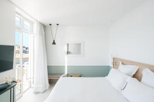 a white bedroom with a large bed and a window at Les Bords De Mer in Marseille