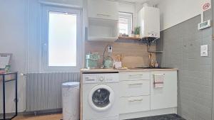 a kitchen with a washing machine and a window at Appartement Oiseau du Paradis avec terrasse parking privé proche centre in Moulins