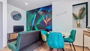 a living room with a couch and a table with chairs at Appartement Oiseau du Paradis avec terrasse parking privé proche centre in Moulins +16 photos