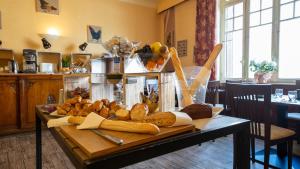 - une table avec du pain et des viennoiseries dans la cuisine dans l'établissement Le Relais Du Canalou, à Digoin