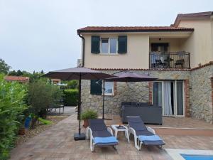 a patio with chairs and umbrellas and a house at Kuca za odmor Vila Agnes in Županje