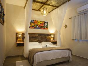 En eller flere senge i et værelse på Pousada de Charme Emirados