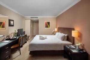 a hotel room with a large bed and a desk at Verdi Budapest Aquincum in Budapest