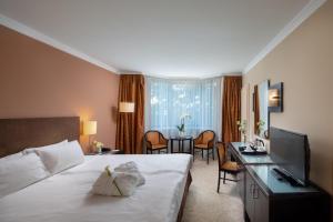a hotel room with a bed and a table and chairs at Verdi Budapest Aquincum in Budapest