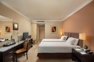 a hotel room with a bed and a desk and a computer at Verdi Budapest Aquincum in Budapest