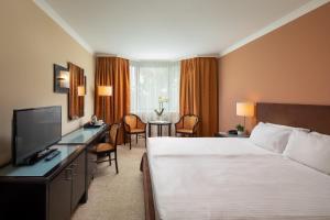 a hotel room with a bed and a flat screen tv at Verdi Budapest Aquincum in Budapest