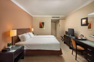 a hotel room with a large bed and a desk at Verdi Budapest Aquincum in Budapest