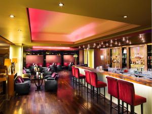 a bar in a restaurant with red chairs at Verdi Budapest Aquincum in Budapest