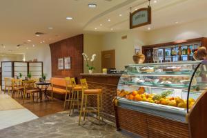 a restaurant with a display case filled with fruit at Verdi Budapest Aquincum in Budapest
