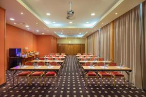 a conference room with tables and chairs and curtains at Verdi Budapest Aquincum in Budapest
