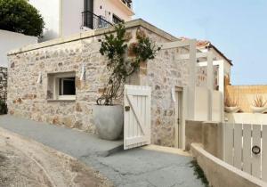 a building with a white door and a potted plant at Synoikies by Oikieskiathos in Skiathos