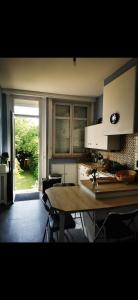 a kitchen with a table and a large window at Grande maison tout confort, billard et spa -en saison in Lys-lez Lannoy