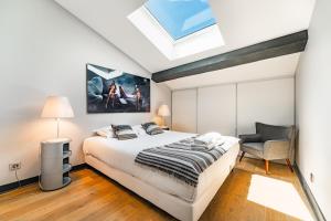 a bedroom with a large bed and a skylight at Appartement Climatisé 3 Chambres Vue Garonne in Bordeaux