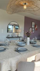 a table with plates and wine glasses on it at Villa Beau Séjour in Fontenay-sur-Mer