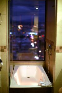 a bath tub in a bathroom with a window at Hotel Zeus in Riobamba