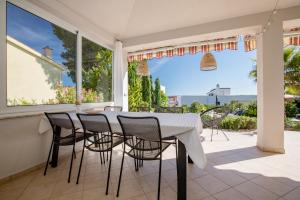 a dining room with a white table and chairs at Holiday House Dolin in Rab