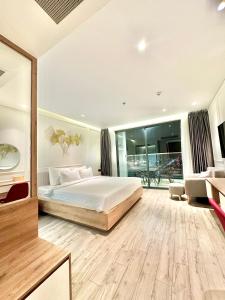 a bedroom with a bed and a living room at White House Condotel Phú Yên in Tuy Hoa