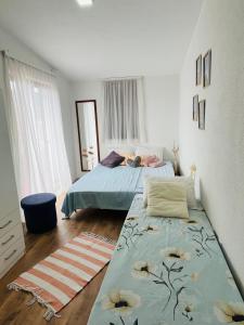 a bedroom with two beds and a rug at Holiday house in Neum