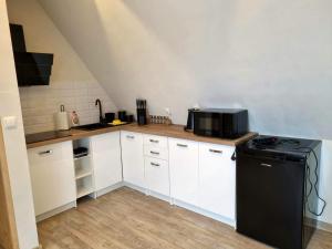 a kitchen with white cabinets and a black refrigerator at Na Sopie in Witów